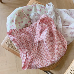 Sacs à bandoulière en coton doux avec motifs de nœuds roses et violets sur une chaise