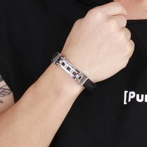 Close-up of men's braided leather bracelet with polished stainless steel buckle on wrist