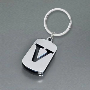 Close-up of a silver rectangular keychain featuring a hollowed-out stylized letter V