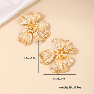 Exaggerated gold metal flower earrings with pearls on silk background for women