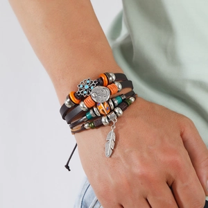 Vintage mehrlagiges Lederarmband mit Schmetterling Stern Mond und Federanhängern am Handgelenk