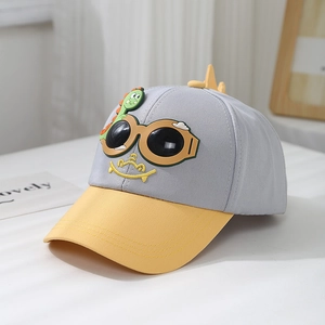 Détail de la broderie dinosaure sur une casquette de baseball en coton gris et jaune