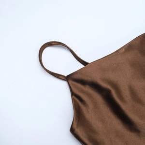 Close-up of brown satin dress with detailed shoulder straps and shiny neckline fabric