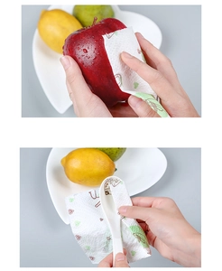 Panno da cucina assorbente con motivi verdi che pulisce una mela e un cucchiaio