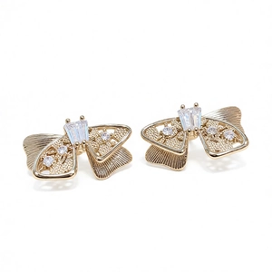 Boucles d'oreilles nœuds dorées avec zircons et finition en métal brossé raffiné
