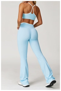 Achteraanzicht van cross-back yoga top en uitlopende broek in babyblauw met witte bies