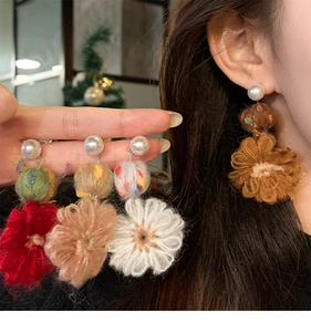 Detailed view of handmade knitted flower earrings with pearls in four elegant colors