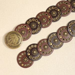Western retro waist belt detail with ornate metal buckle and leather floral rivet disks