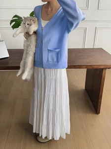 Minimalist light blue knit cardigan with gold buttons paired with white tiered skirt