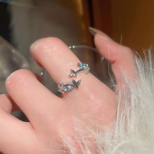 Close-up of elegant silver butterfly ring with light blue zircon stones on hand