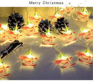 Detail of snowman LED fairy lights with warm yellow glow and festive pine cone decor
