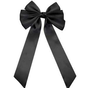 Elegant black satin bow hair clip with long ribbons on a white background