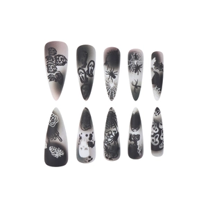 Halloween press-on nails with skull and spider web designs on long almond shaped tips
