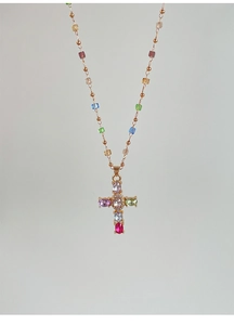 Détail macro du collier pendentif croix en pierres colorées avec chaîne à perles dorées