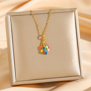 Colorful hot air balloon pendant necklace with gold chain on a premium silk background