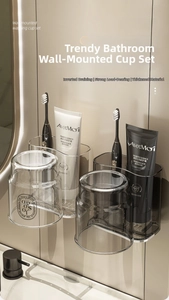 Detail of wall-mounted toothbrush holder with grey translucent cups and drainage function