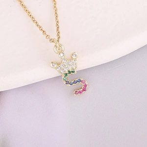 Macro detail of 18K gold letter S pendant with colorful zircon crown on a fine chain