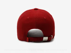 Detail view of the back of a dark red baseball cap with adjustable metal buckle and tag