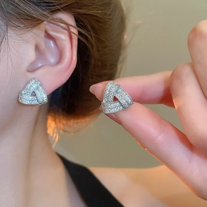 Detail view of silver triangle stud earrings with shiny pave cubic zirconia stones