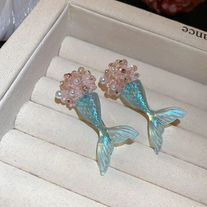 Detailed macro view of mermaid tail earrings with sparkling blue fins and small pearls