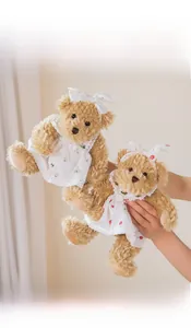 Detail of two teddy bears in lace strawberry dresses with matching headbands
