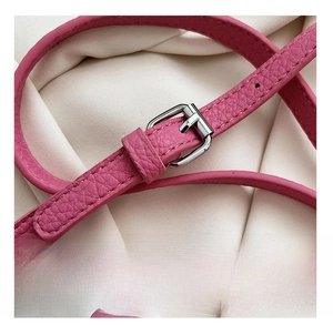 Detailed shot of pink lychee leather adjustable shoulder strap with silver buckle