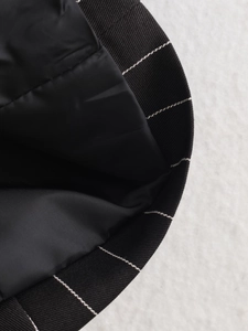 Macro detail of black striped fabric showing the ribbed cuff and smooth inner lining quality