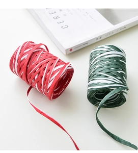 Dettaglio di rotoli di carta rafia rossa e verde per confezioni regalo natalizie