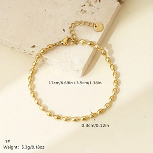 Detail of golden stainless steel beaded bracelet showing lobster clasp and adjustable chain