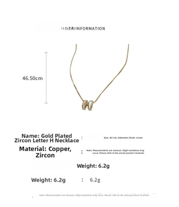 Detail view of the gold-plated H-letter pendant necklace with zircons and white inlay
