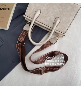 Detail of beige tote bag with textured faux leather and patterned jacquard strap
