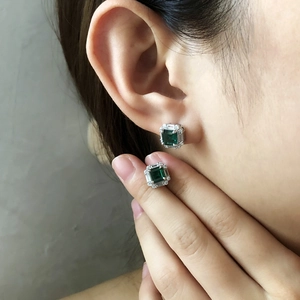 Close-up of S925 silver emerald-cut sugarloaf studs with white zircon halo on ear