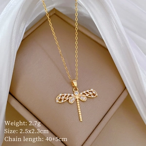 Macro view of gold dragonfly necklace with crystal inlay in a beige jewelry box