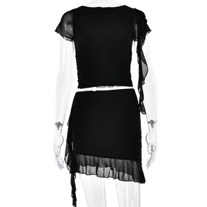Two-piece black slim fit set featuring a ruched crop top and asymmetric mesh ruffle skirt