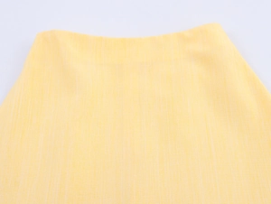 Close-up of yellow linen-textured fabric showing intricate weave and premium stitching