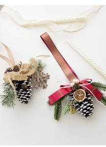 Detail of Christmas pinecone ornaments with linen bows, wooden snowflakes and gold bells
