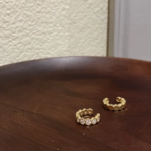 Set de bagues d'oreille hexagonales dorées avec zircon blanc sur support bois