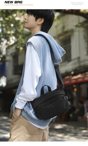 Minimalist black nylon crossbody bag with adjustable strap worn by model in street setting