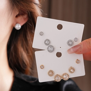 Dettaglio di set di orecchini a lobo in zircone argento e oro con design halo su schede