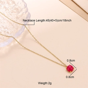 Macro detail of gold necklace featuring an 8mm red stone pendant with length specs
