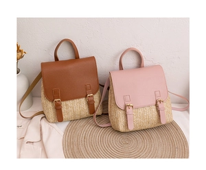 Detail of hand-woven straw backpacks with leather flaps in brown and pink colors