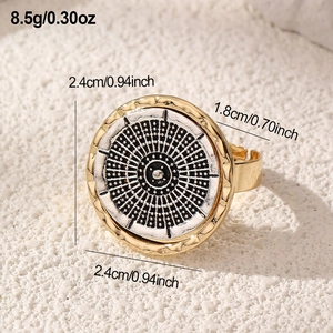 Close-up of vintage round ring with black and white dot pattern and gold relief edge