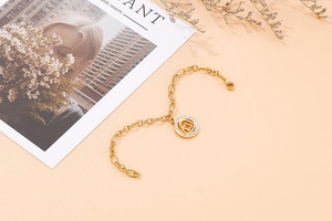 Detailed shot of golden link chain bracelet with a sparkling crystal flower pendant