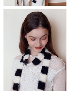 Detailaufnahme eines weichen schwarz-weißen Strickschals an einem weiblichen Model