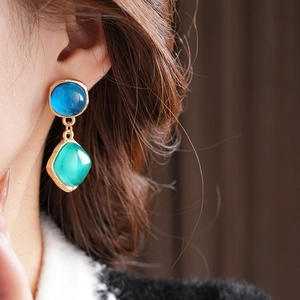 Macro de boucles d'oreilles vintage avec cercles bleus et pendentifs en résine verte
