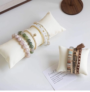 Detail of bohemian leather bracelets and pearl beads on soft velvet display pillows