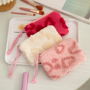 Three-piece plush makeup bag set in white, pink, and rose with heart patterns