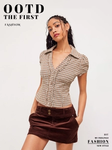 Close-up of vintage brown plaid shirt with ruffle trim and textured corduroy skirt