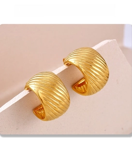 Detailed view of 18k gold plated PVD C-shape earrings with textured horizontal stripes