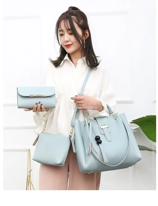 Detailed view of light blue three-piece bag set with tassel charms and PU leather texture